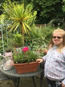 Club Member, Cerys, next to a plant bought at the Plant, Cake, Craft, and Book Sale